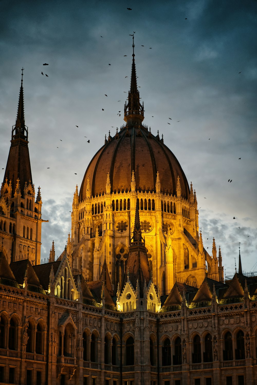 a large building with a dome and many birds flying around it