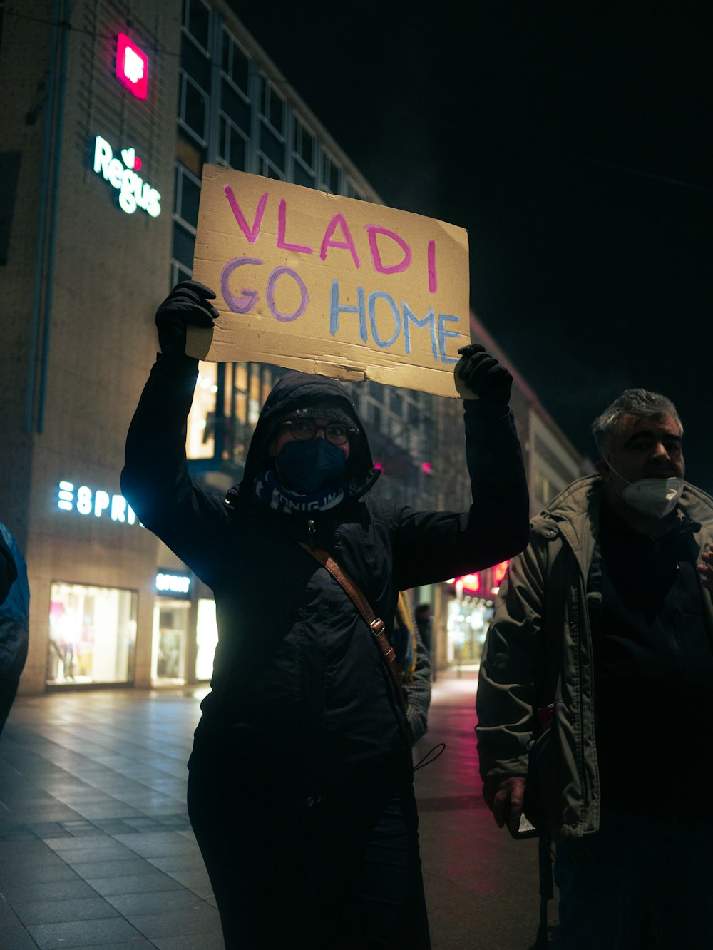 a person holding a sign that says vladi go home