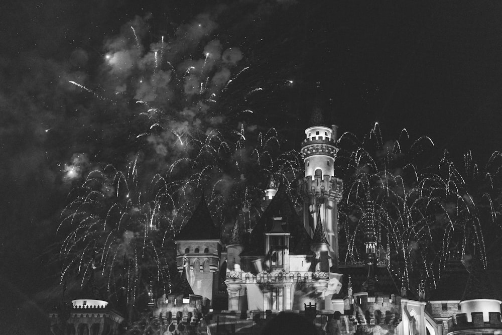 a black and white photo of a castle with fireworks