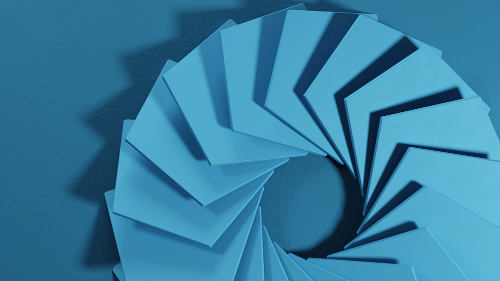 a spiral of blue paper on a blue wall