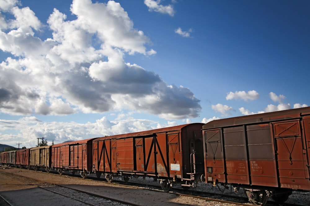 a train traveling down train tracks under a cloudy sky