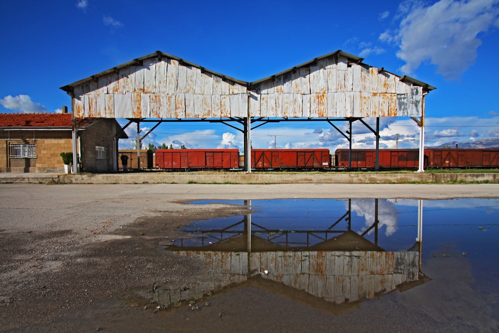 a building with a train on top of it next to a body of water