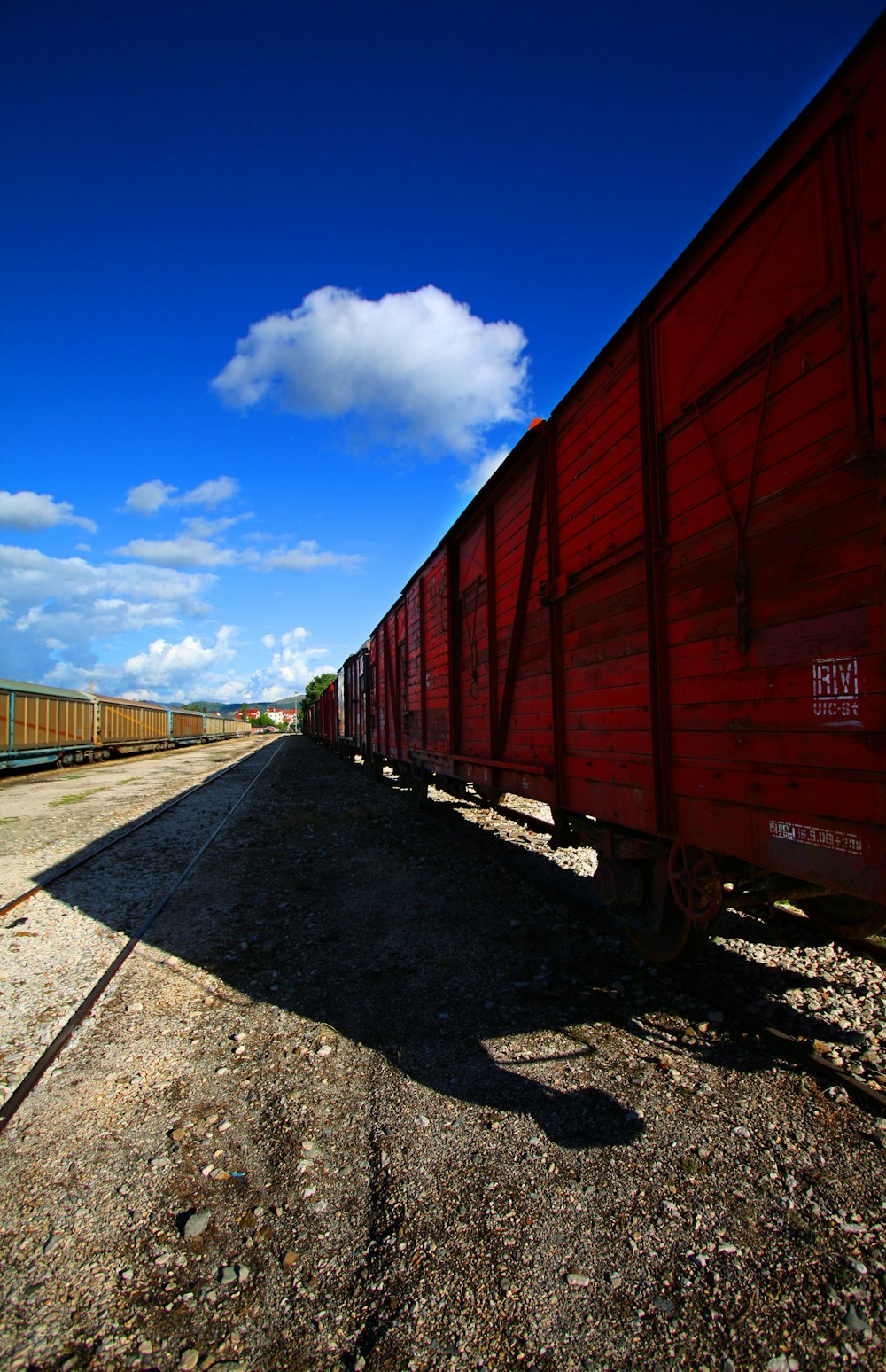a long red train traveling down train tracks