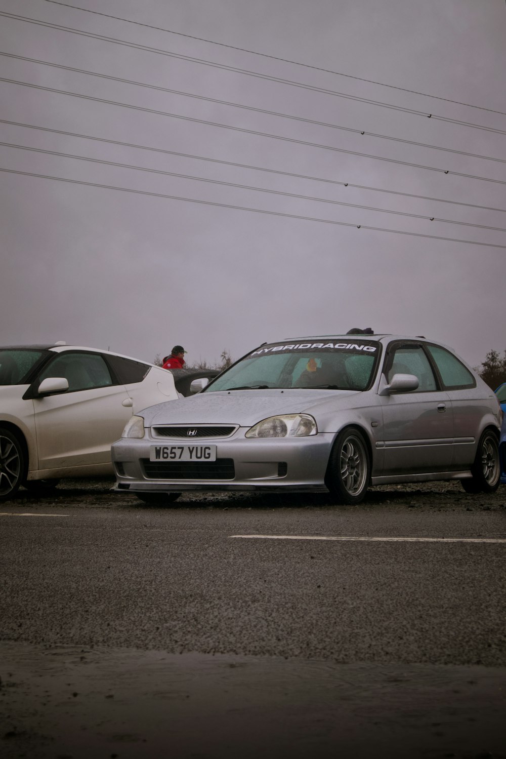 two cars parked next to each other in a parking lot