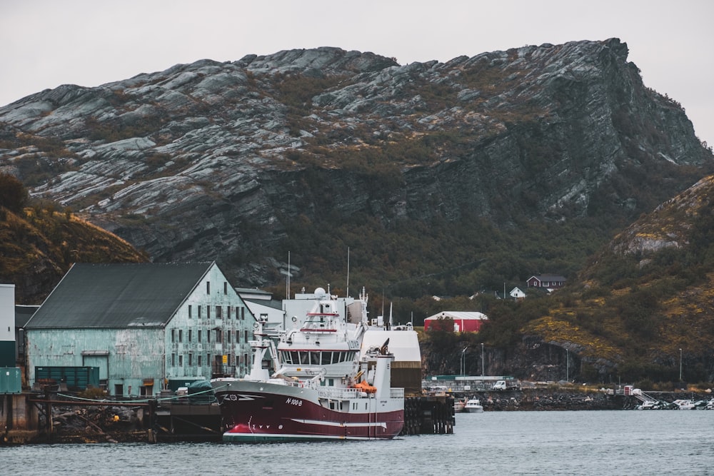 a large boat in a body of water near a mountain