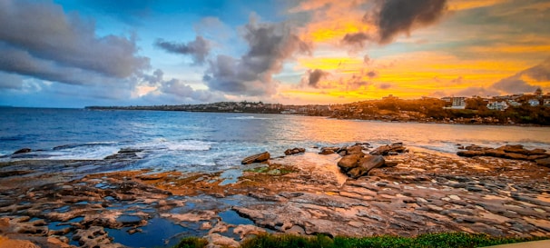A vibrant sunset casting warm colors over a rocky coastline.