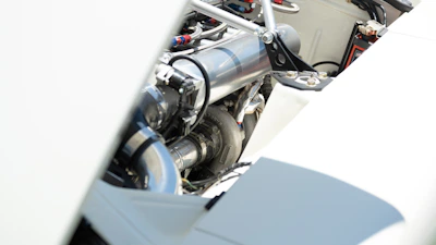 Various engine parts and lubricants arranged on a clean workbench.