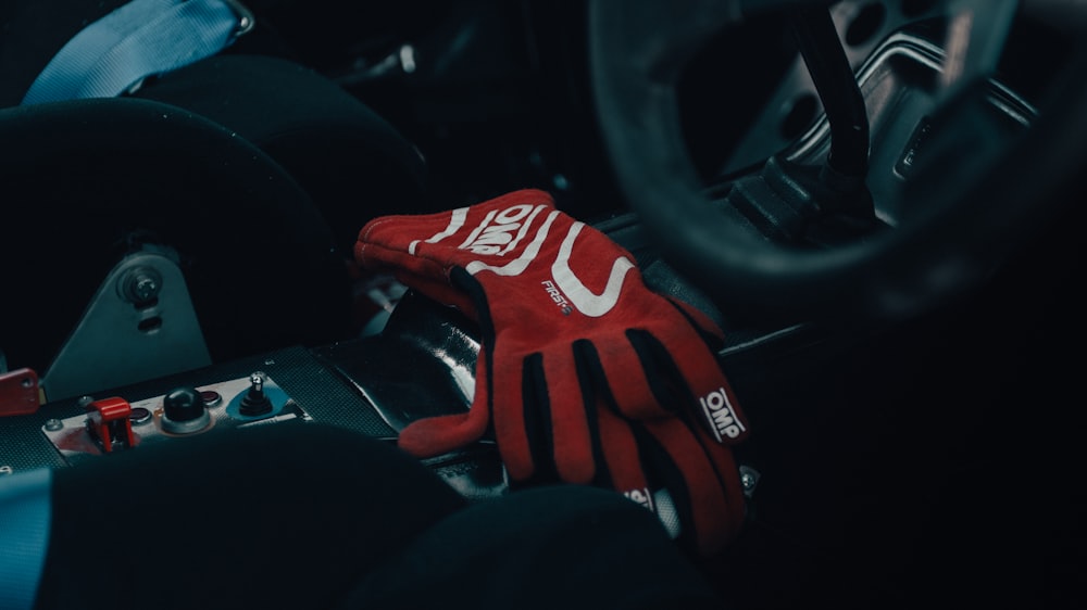 a red glove sitting on top of a steering wheel