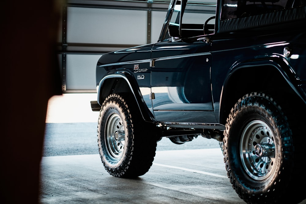 a black jeep is parked in a garage