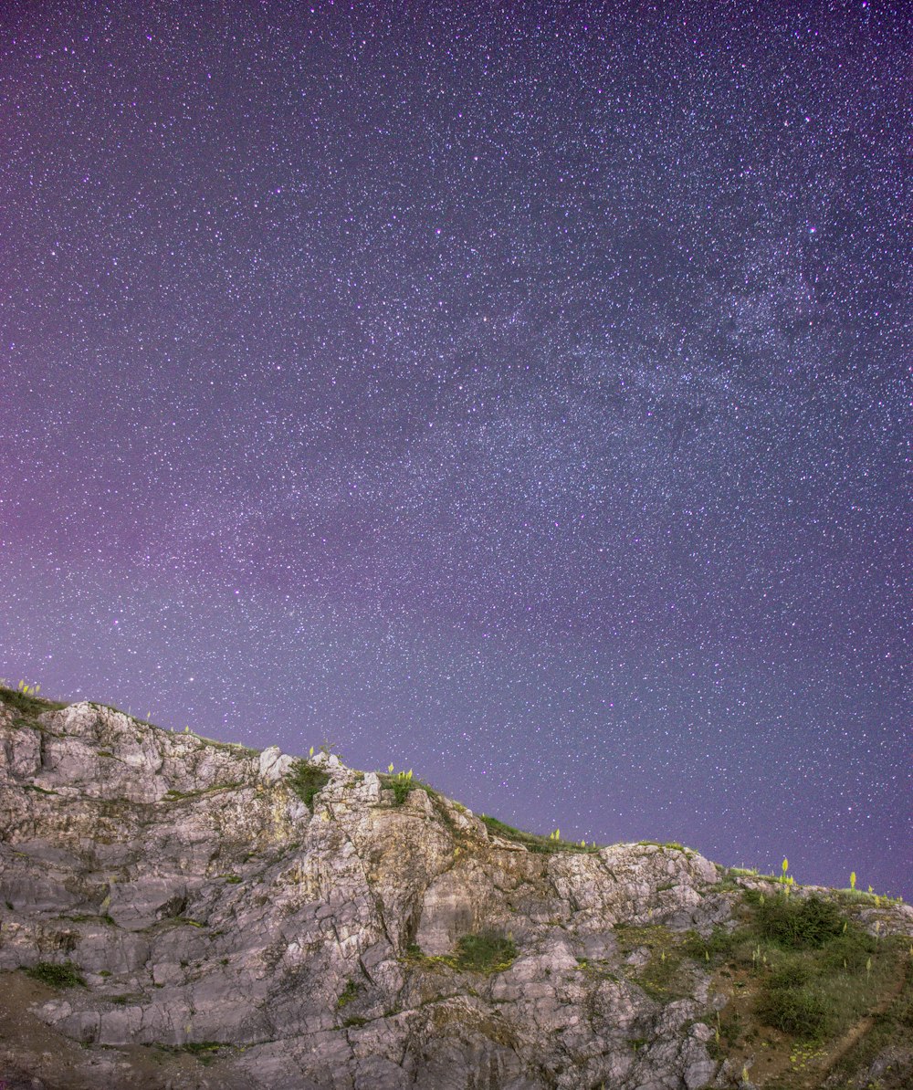 a person standing on top of a mountain under a purple sky