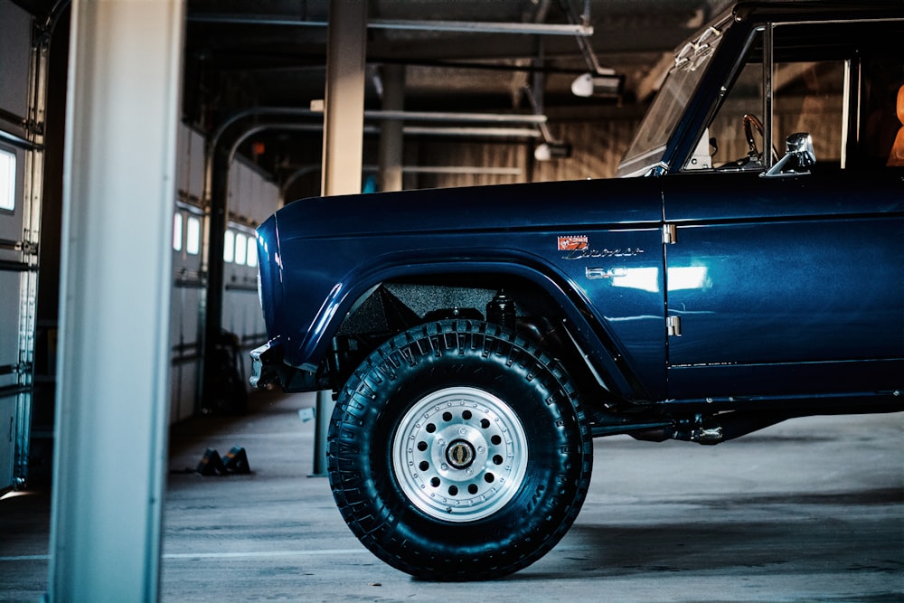 a blue truck parked inside of a garage