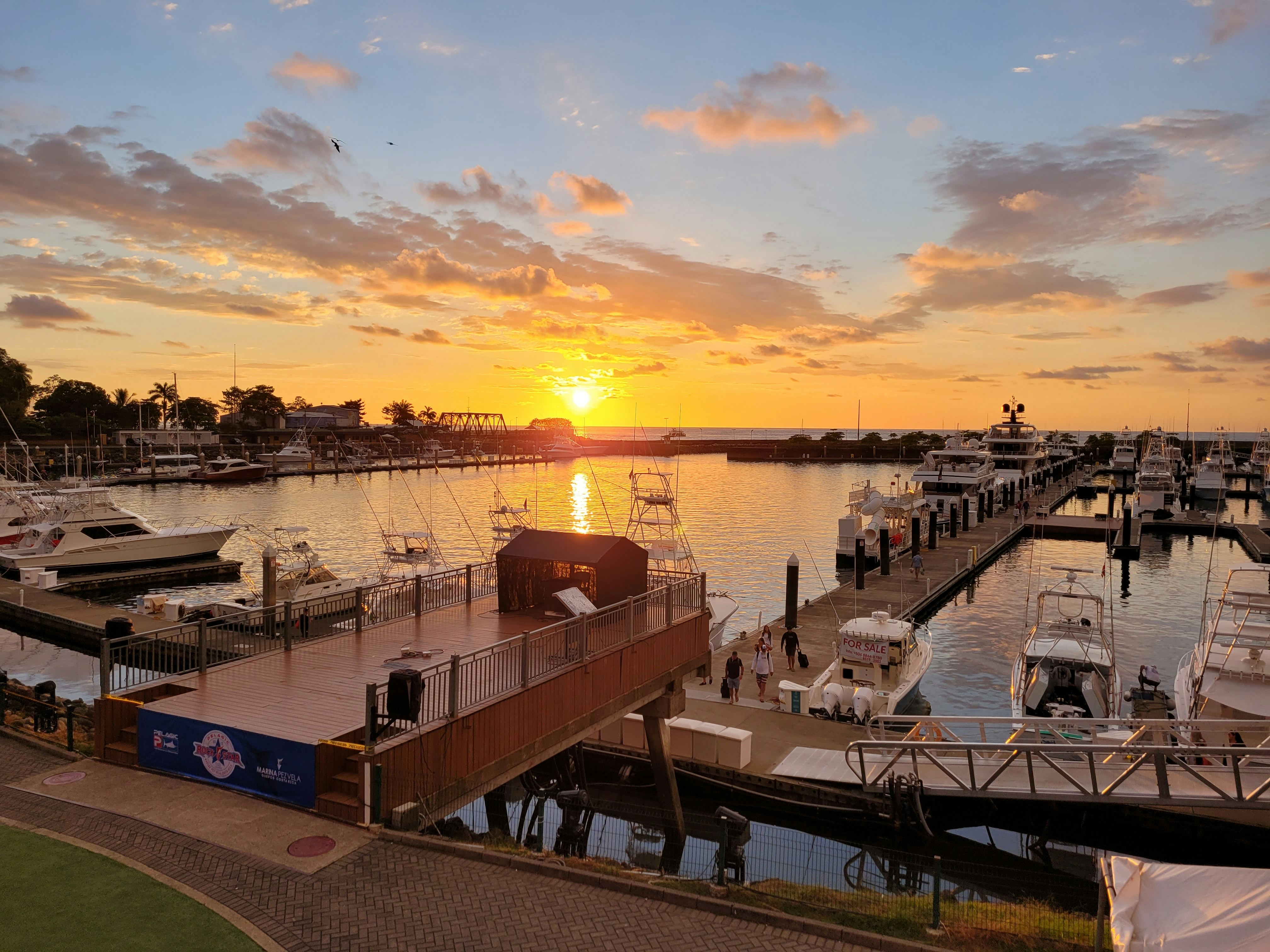 the sun is setting over a marina with boats