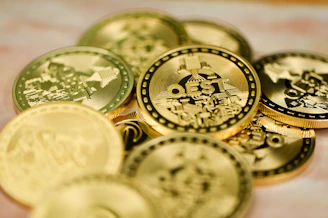 a pile of gold and silver coins sitting on top of a table