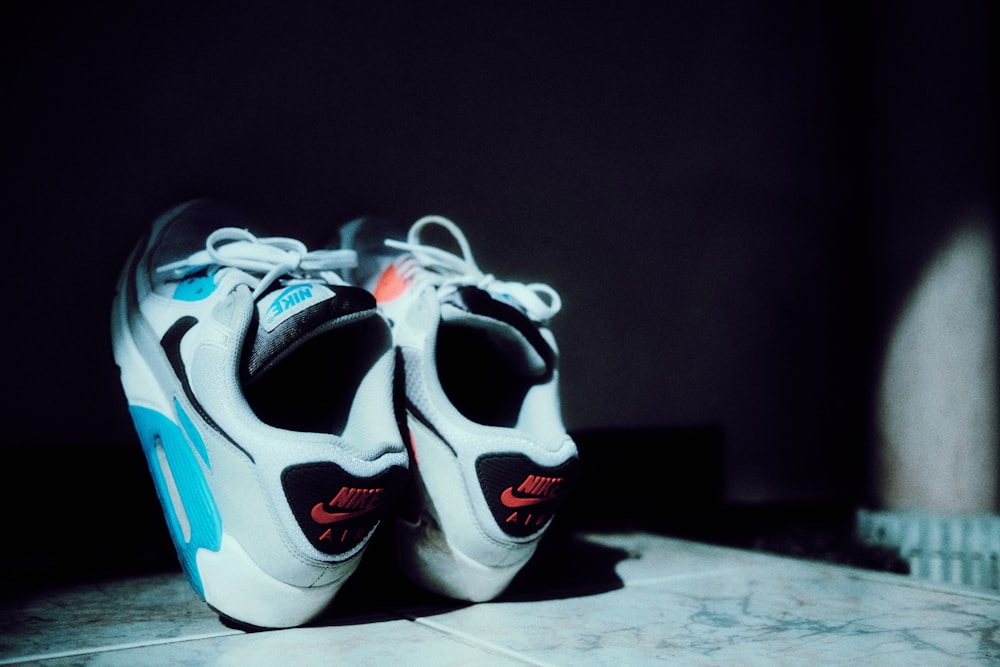 a pair of shoes sitting on top of a tiled floor