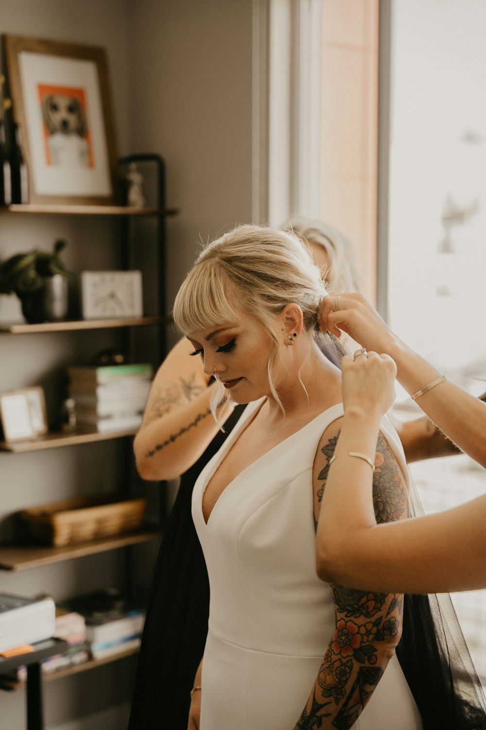 a woman in a white dress getting her hair done