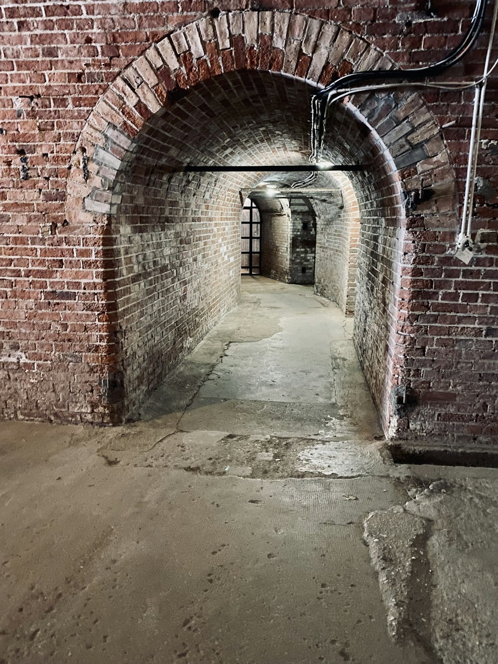 a brick tunnel with a pipe running through it