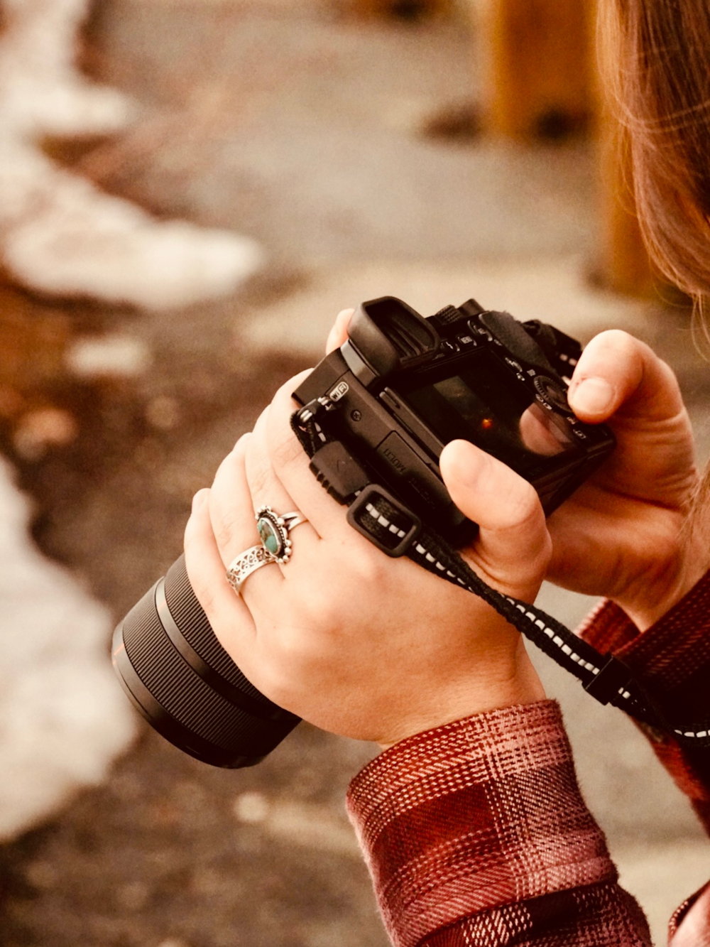 uma mulher segurando uma câmera em sua mão