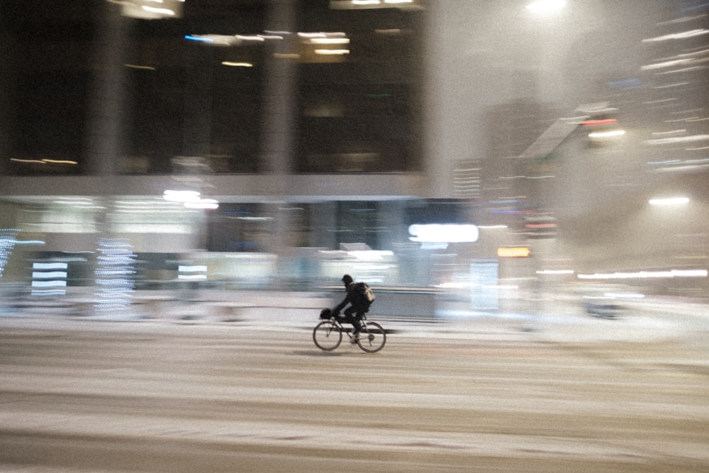 a man riding a bike down a snow covered street