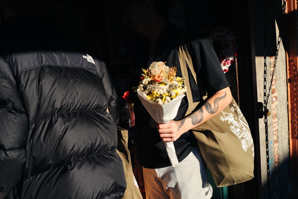 a man holding a bouquet of flowers in his hand