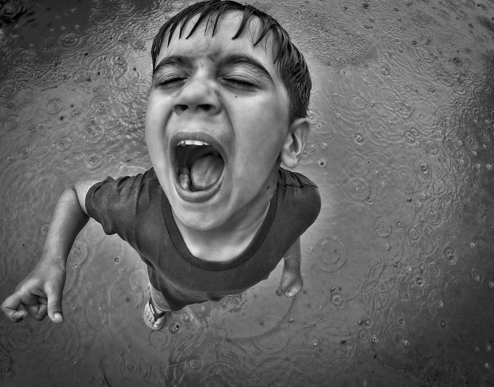 a young boy with his mouth open in the water