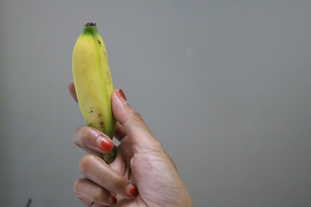 a person holding a banana in their hand