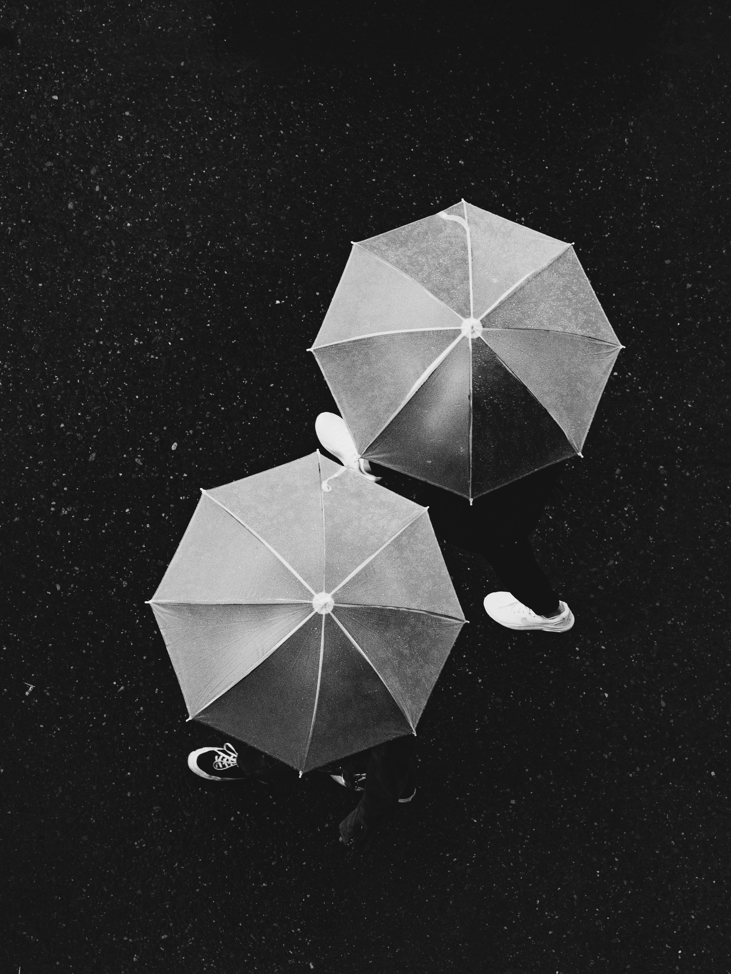 two open umbrellas sitting on top of a black surface
