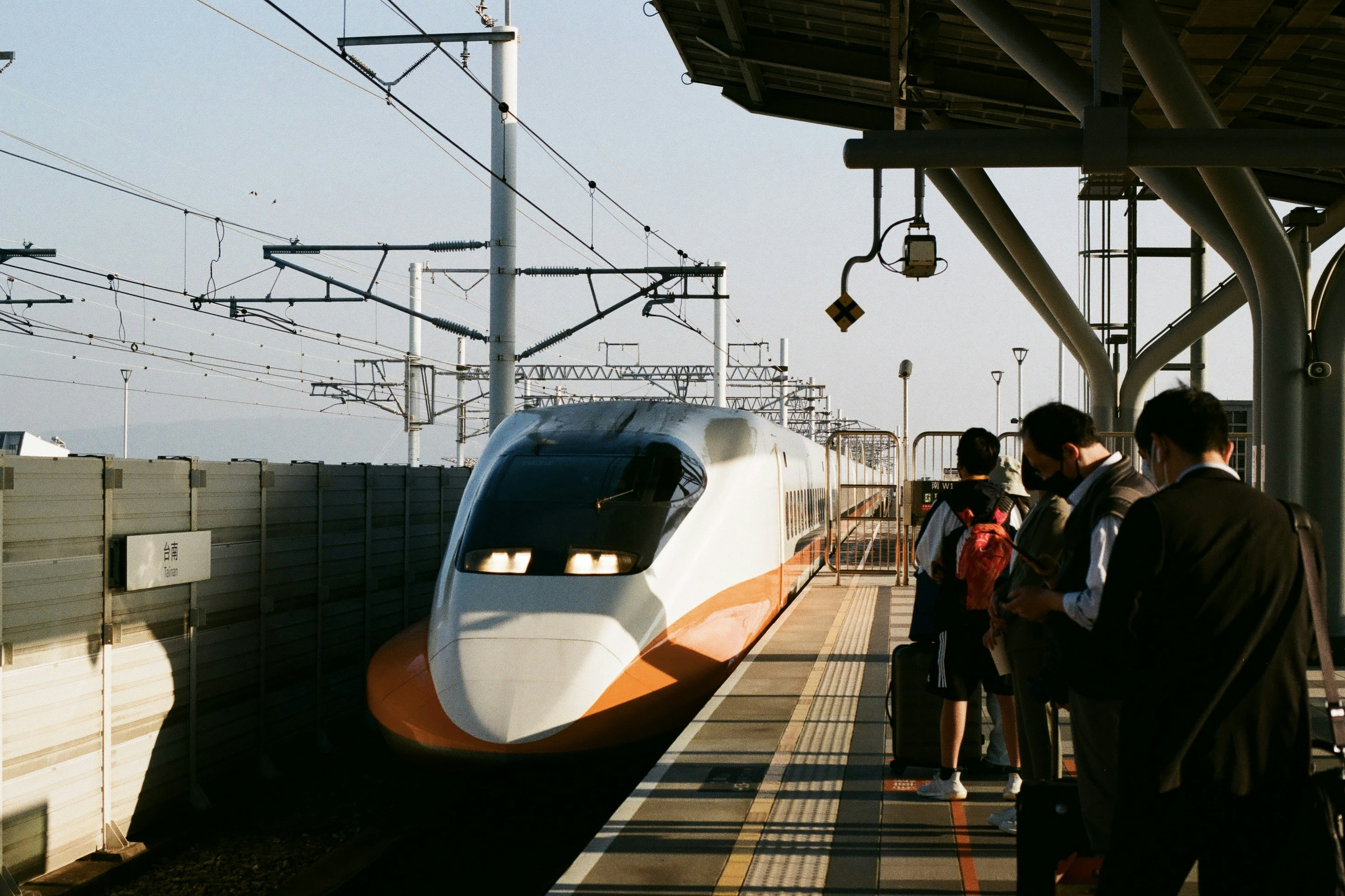a group of people standing on a platform next to a train