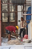 a couple of men working on a piece of wood