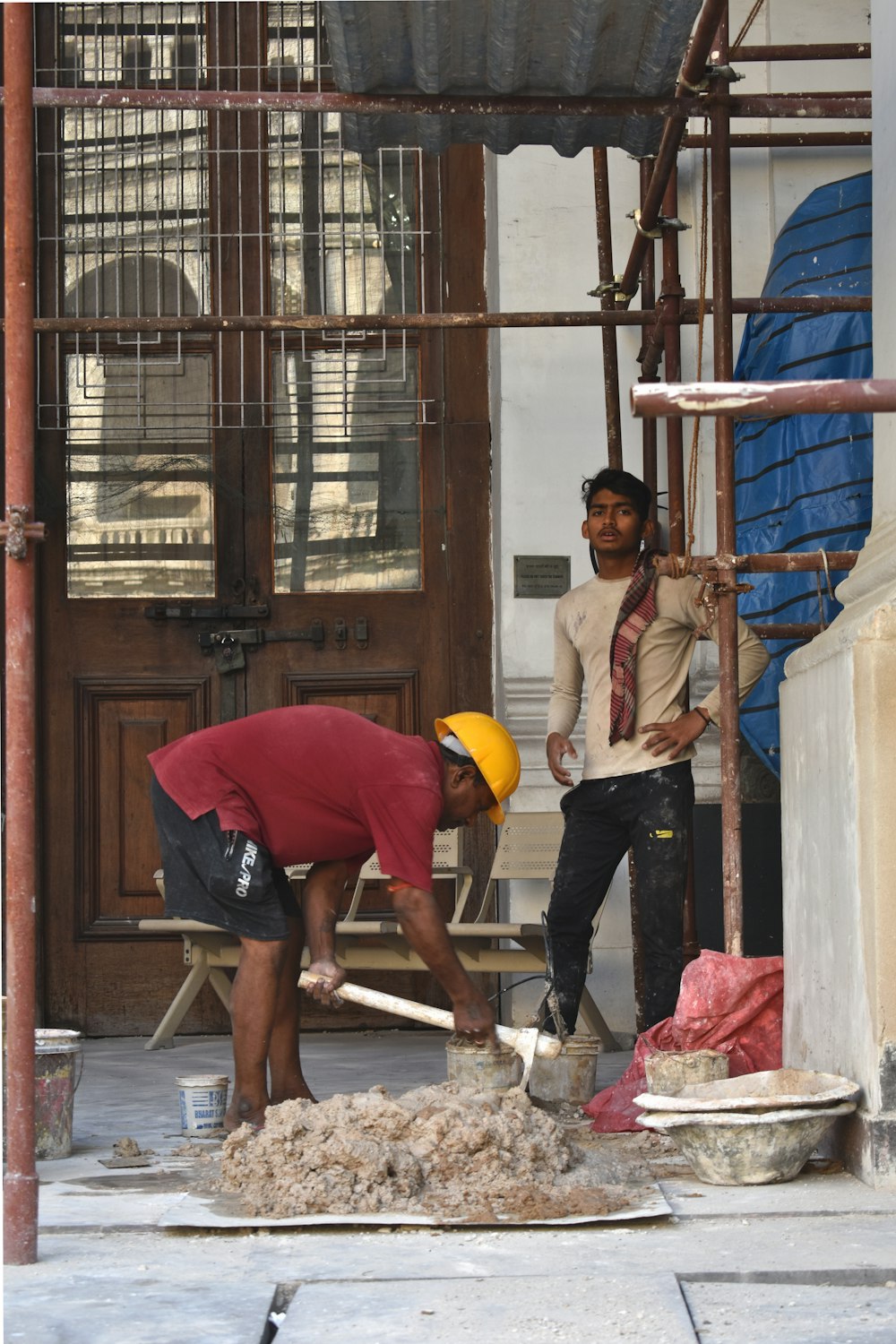 a couple of men working on a piece of wood