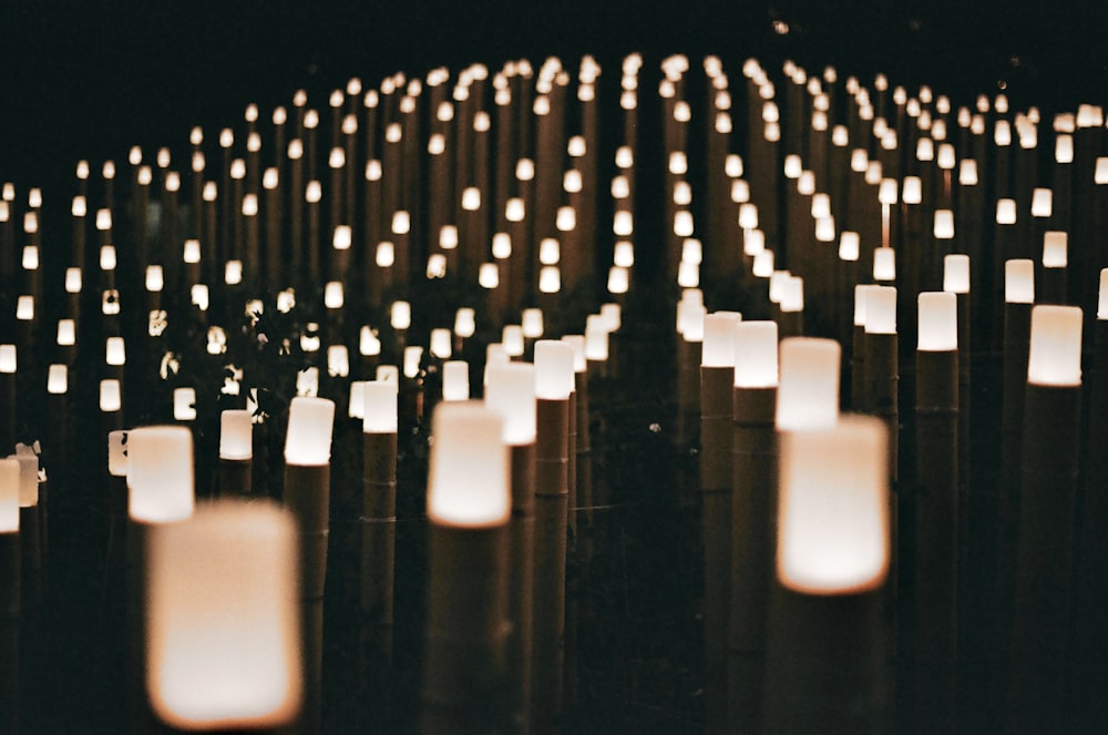 rows of lit candles in a dark room