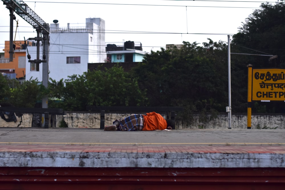 a homeless man sleeping on the side of the road