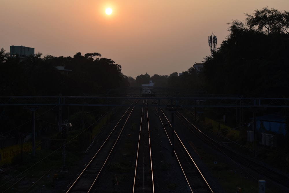 the sun is setting over a train track