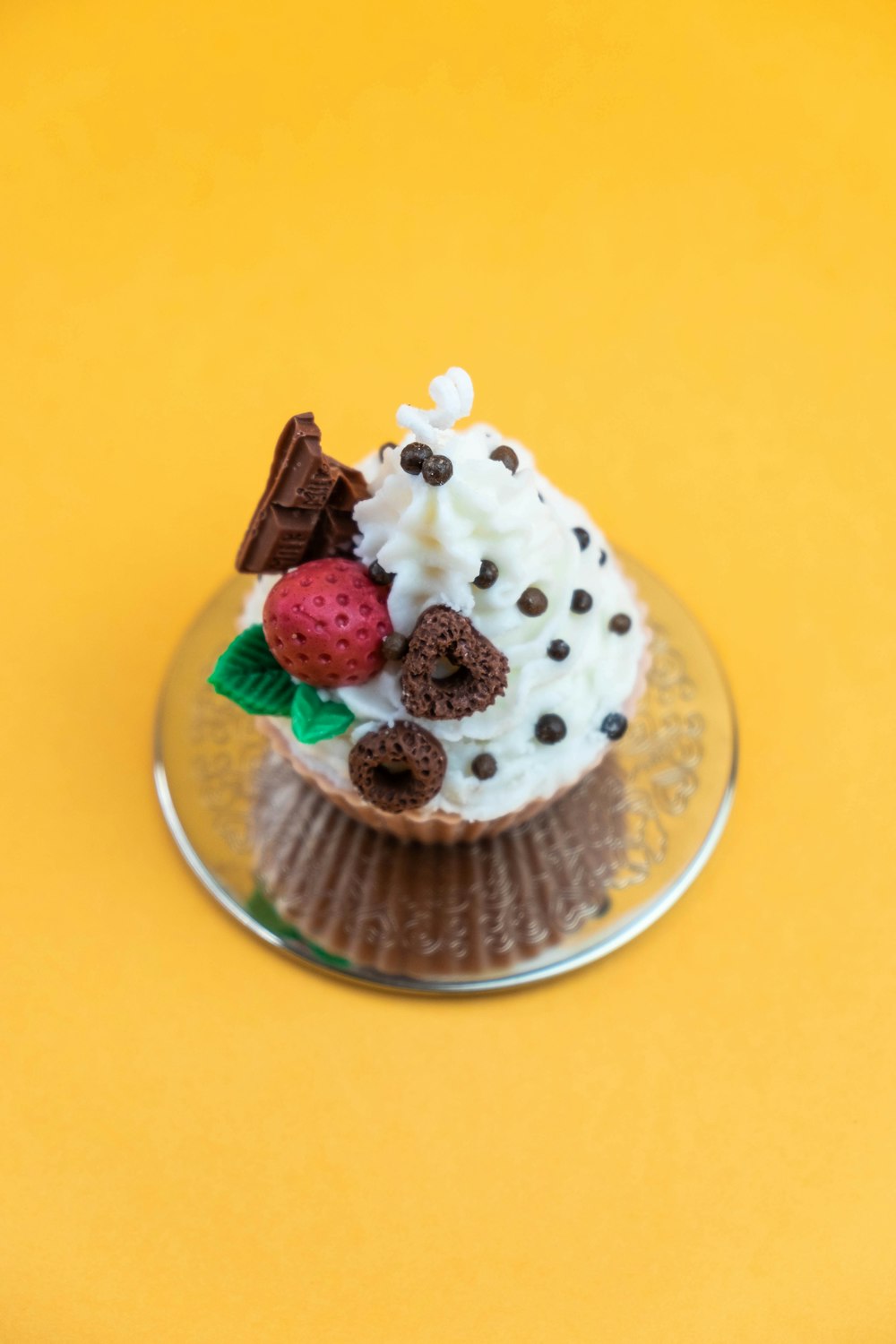 ein Cupcake mit Schokoladenstückchen und Erdbeeren oben drauf