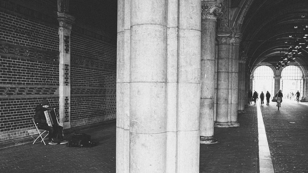 a black and white photo of a person sitting on a bench