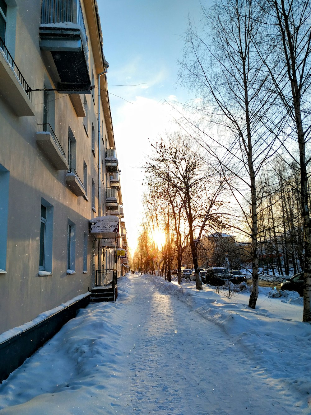 uma rua coberta de neve ao lado de um edifício