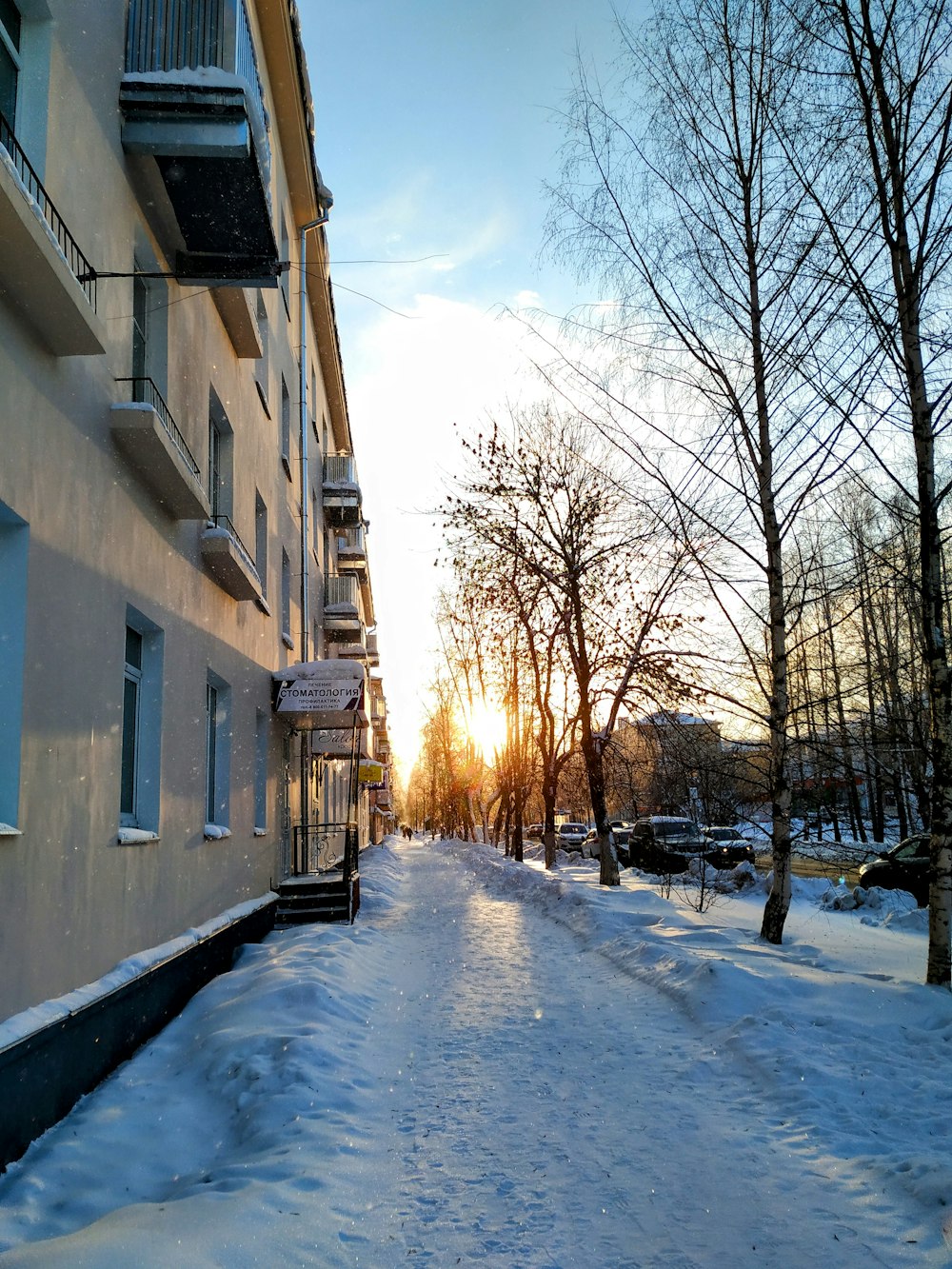 a snow covered street next to a building