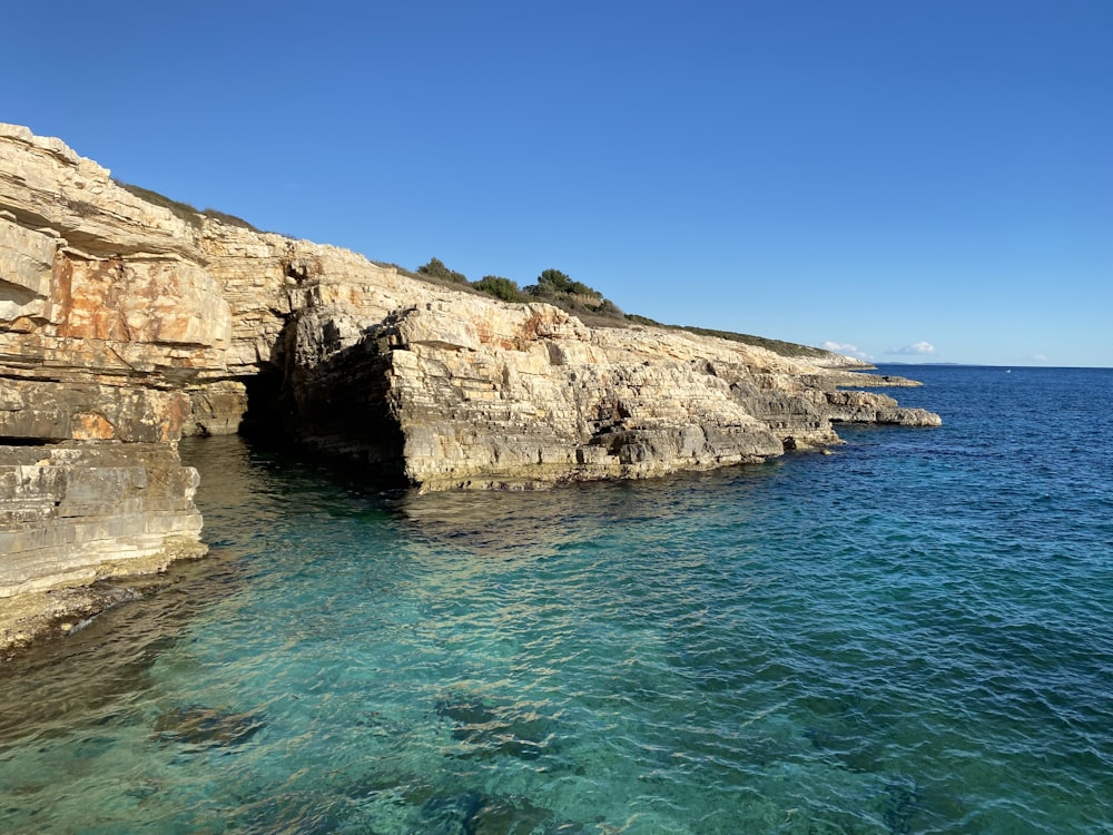 a large body of water near a rocky cliff