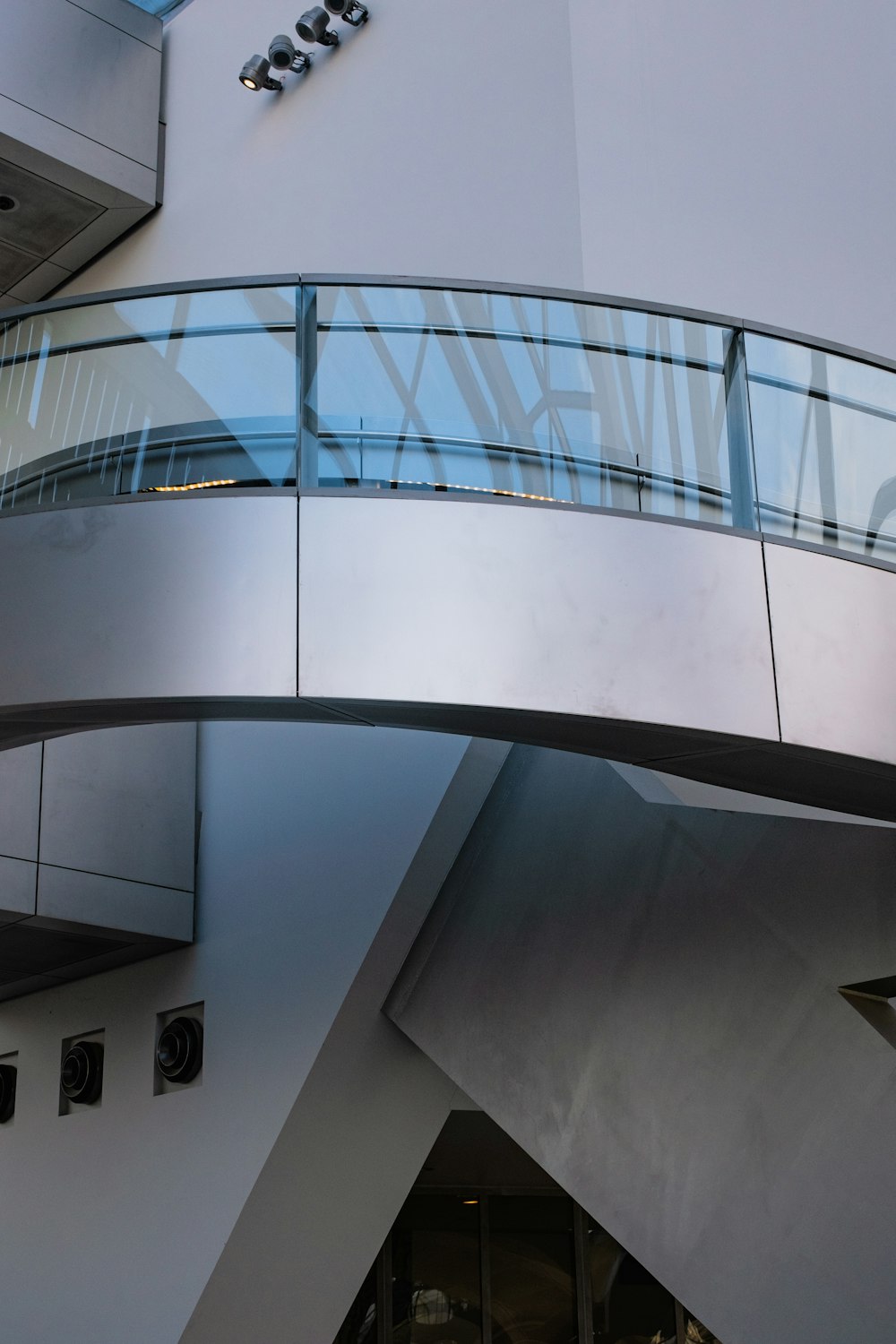 a glass and metal walkway going up to a building