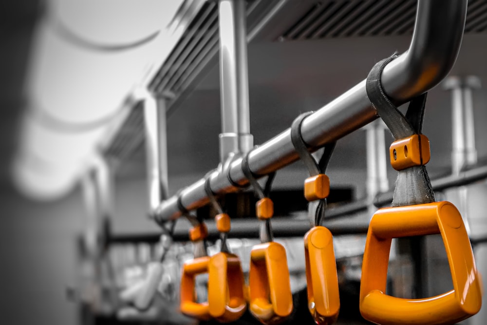 a row of orange handles on a bus