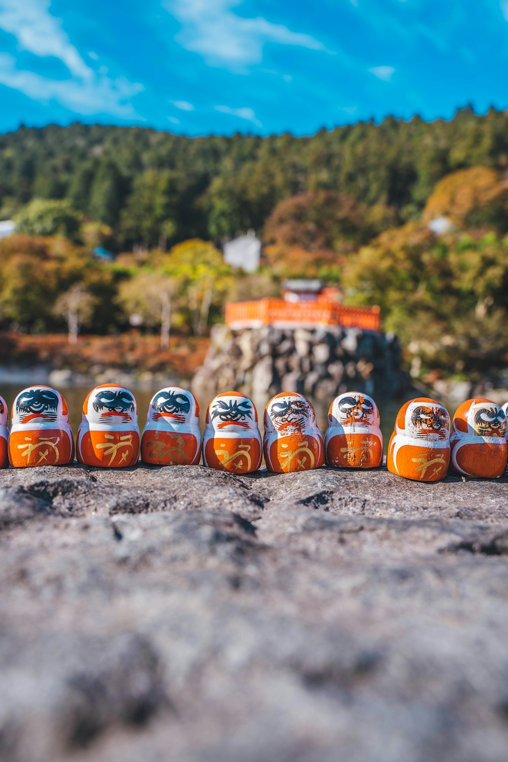 a group of orange and white dolls sitting on top of a rock