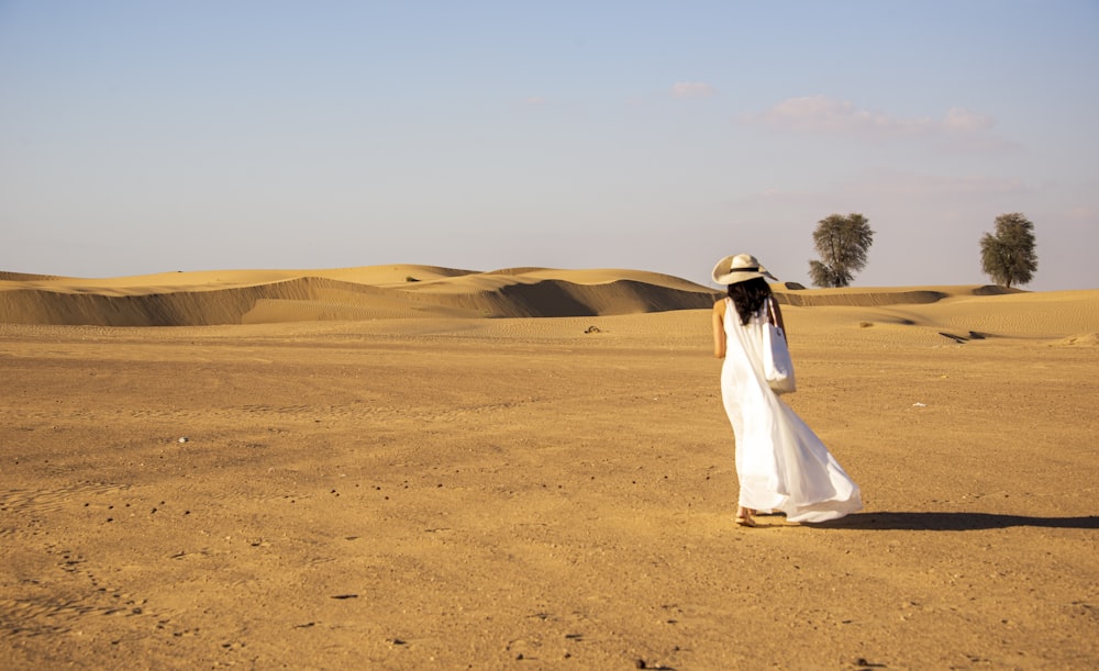 a woman standing in the middle of a desert