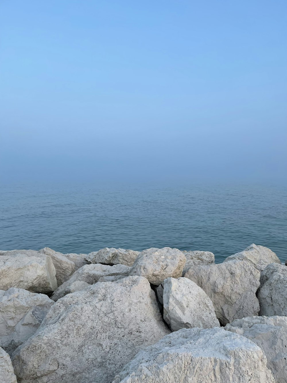 a view of a body of water from a rocky shore
