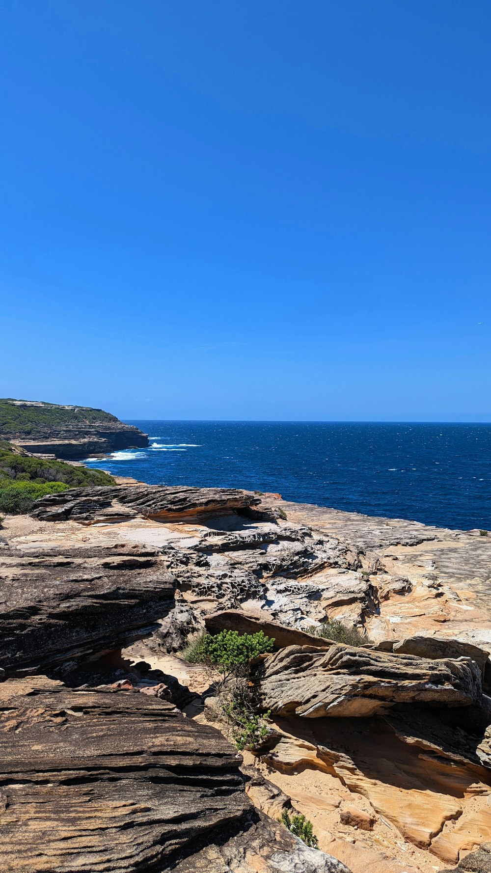 a bench sitting on the edge of a cliff overlooking the ocean