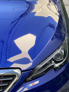 a close up of the hood of a blue car