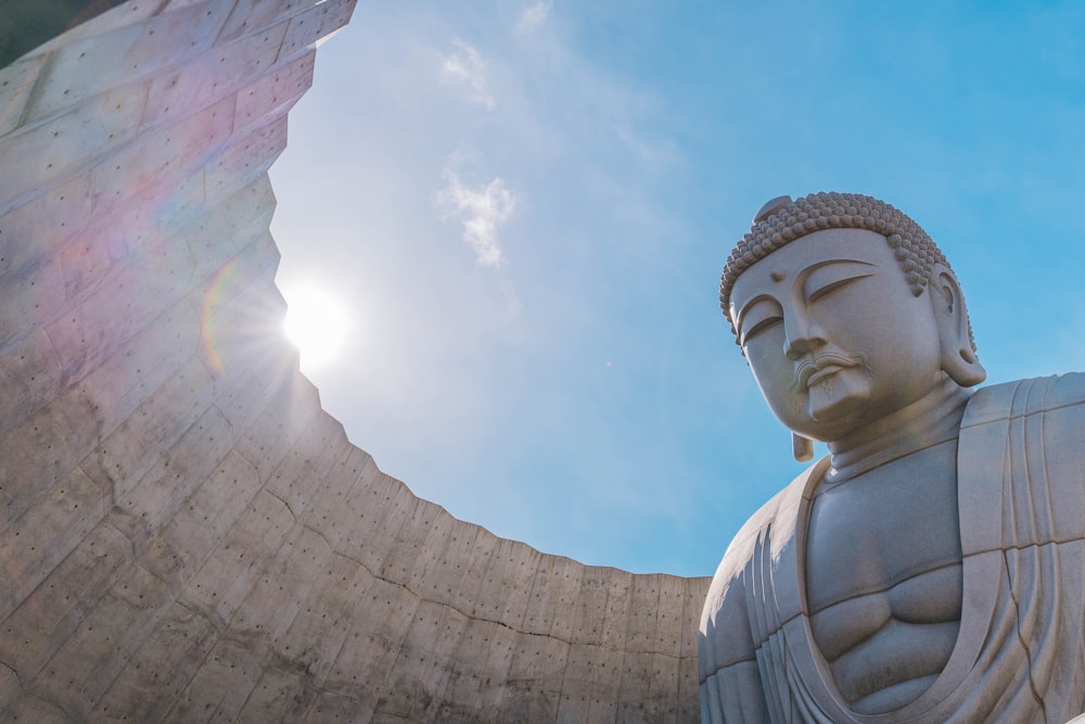 a statue of a buddha in front of the sun