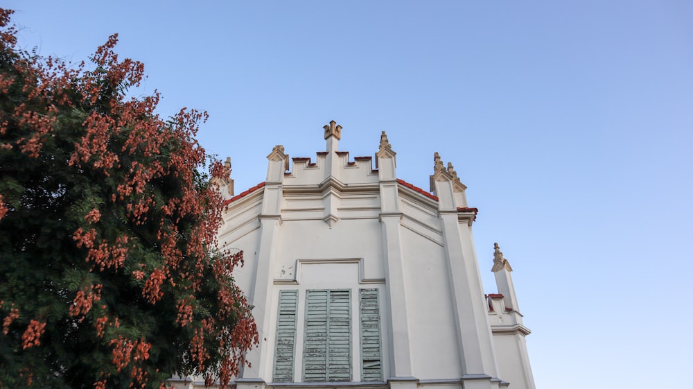 a tall white building with a cross on the top of it