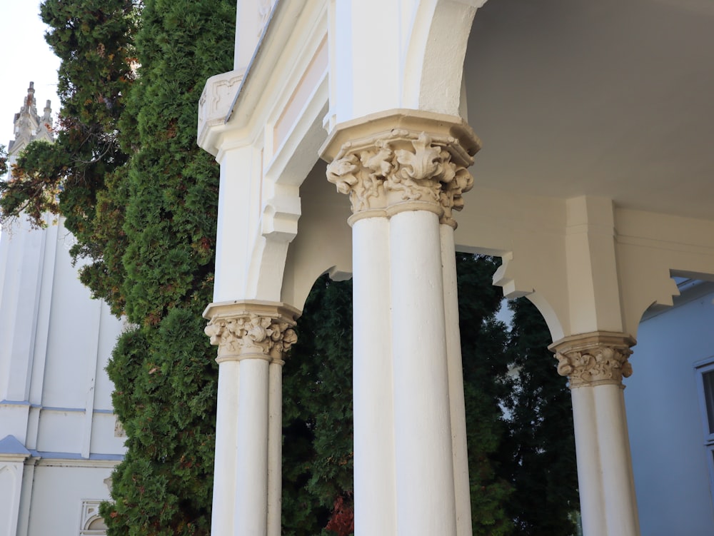 a white building with columns and a clock tower in the background