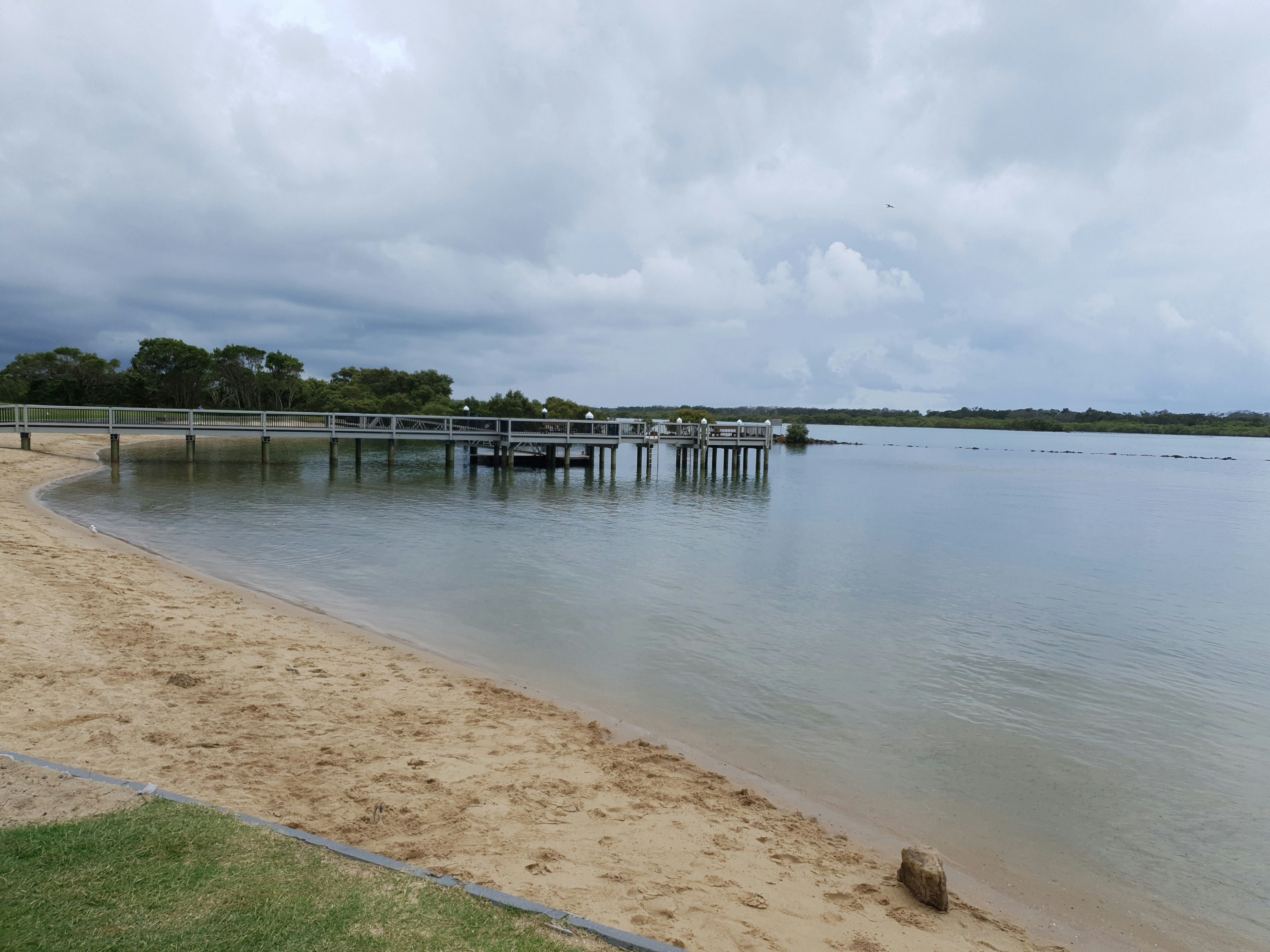 a beach with a pier and a body of water