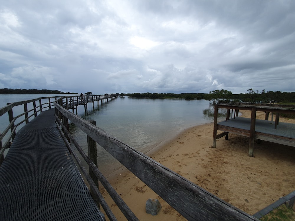 a wooden pier sitting on top of a sandy beach