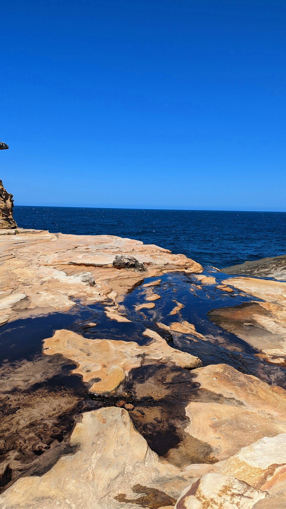 a bench sitting on top of a rocky cliff next to the ocean